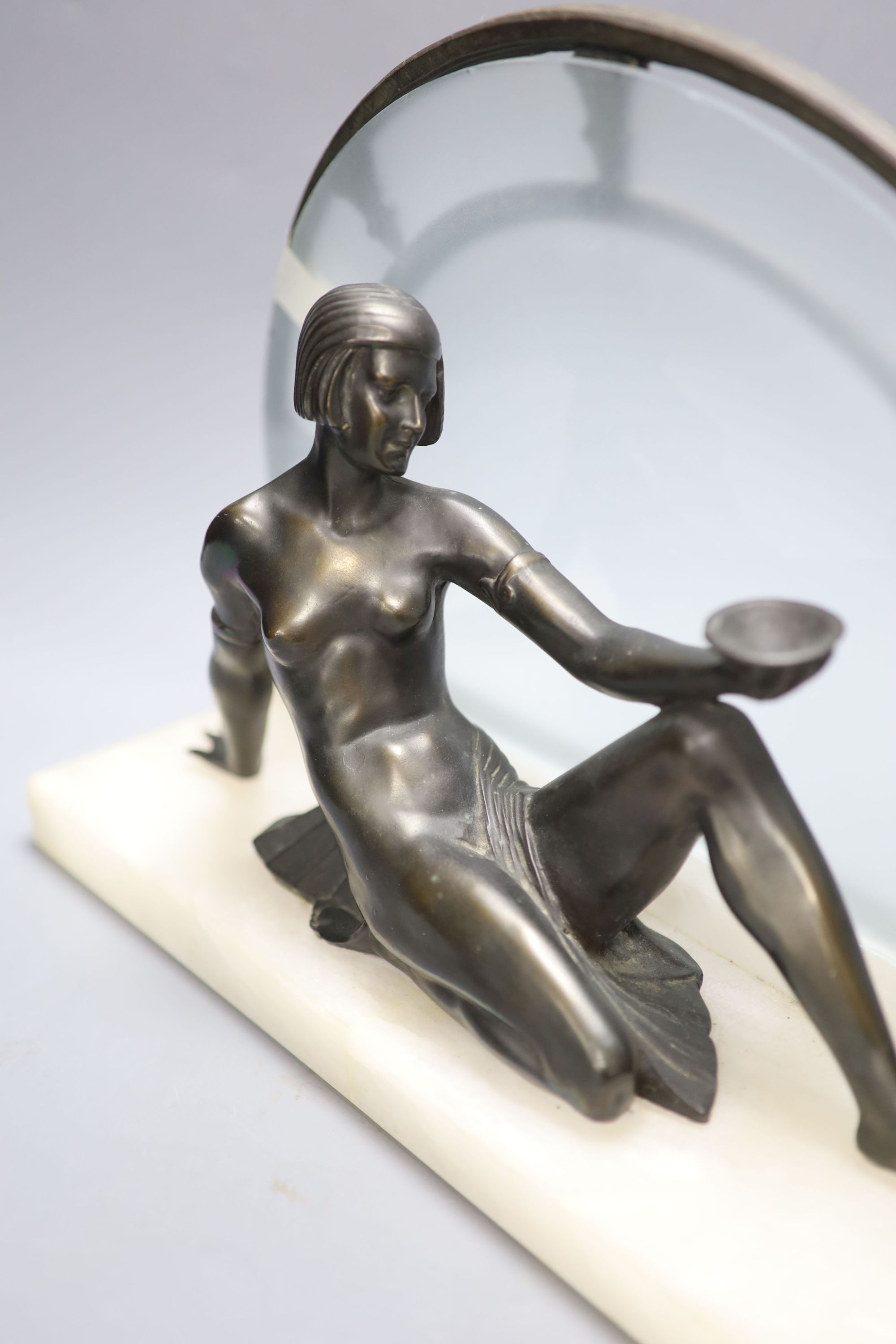 An Art Deco style bronze of nude reclining female figure on white marble plinth, length 42cm